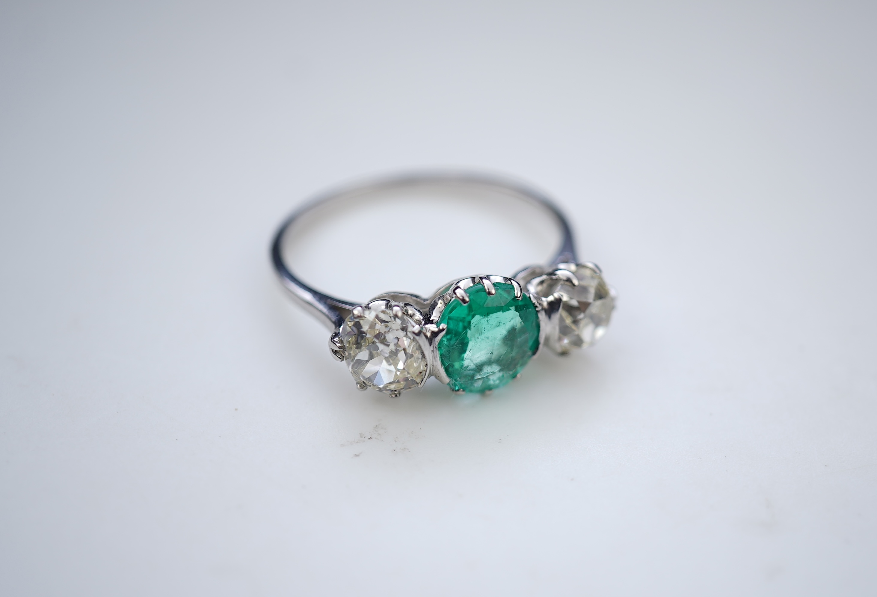 An attractive emerald and diamond three-stone ring, early 20th century